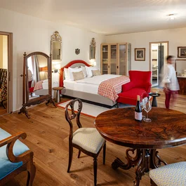 Gemütliches Hotelzimmer mit Doppelbett und antiken Möbeln