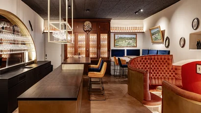 Modernes Barinterieur mit Lederbänken und bunten Barhockern