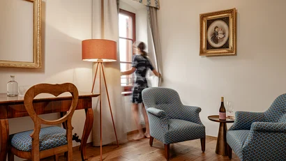 Gemütliche Sitzecke mit zwei Sesseln, Tisch und Person am Fenster