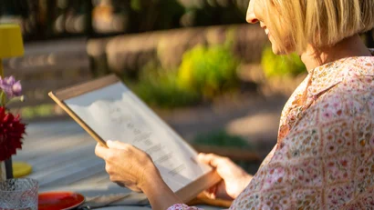 Frau liest Speisekarte beim Mittagessen im Freien