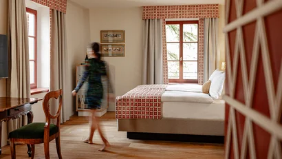 Schlafzimmer mit Bett, Holzfußboden und bewegter Person