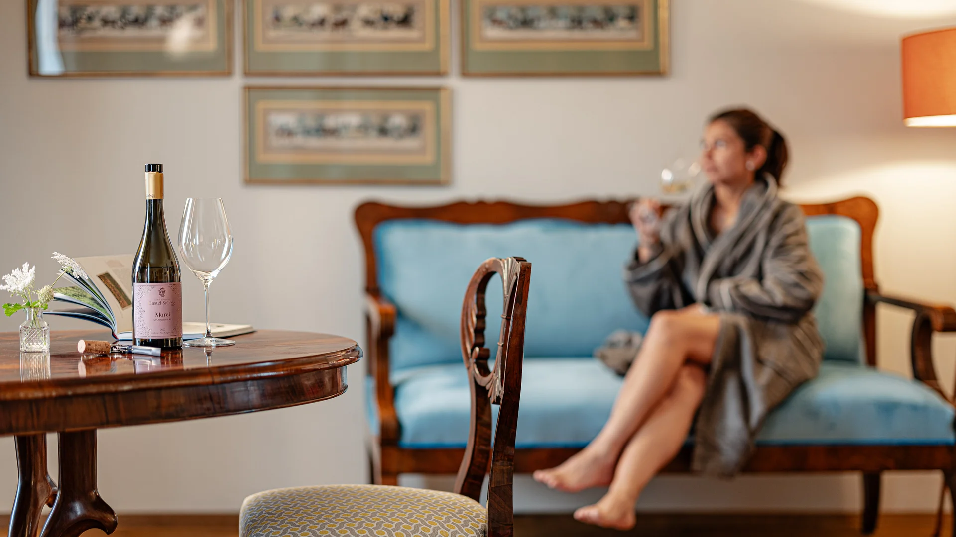 Frau entspannt mit Wein in einem gemütlichen Wohnzimmer mit antiken Möbeln