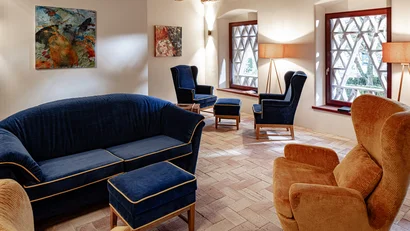 Gemütlicher Wohnraum mit blauen und braunen Sesseln und Sofas